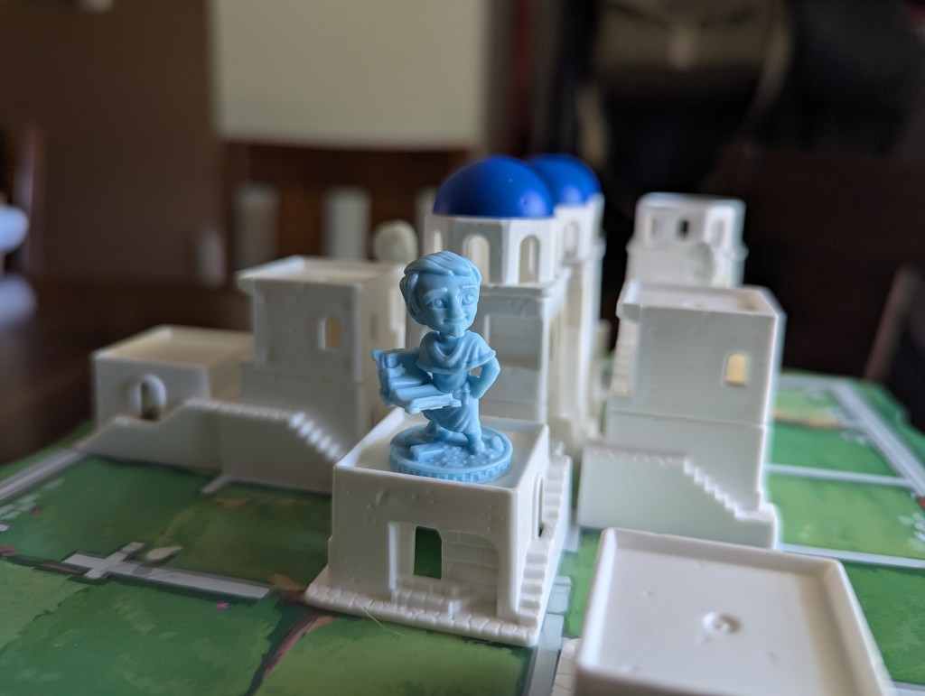 A closeup of one of the builder miniatures on top of a 1 story building.