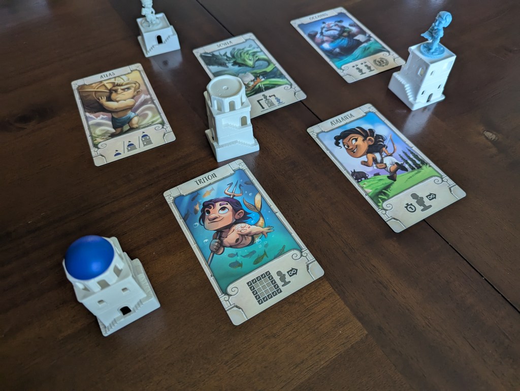 A set of 5 cards set up ready to be drafted, alongside a couple of the buildings and miniatures.