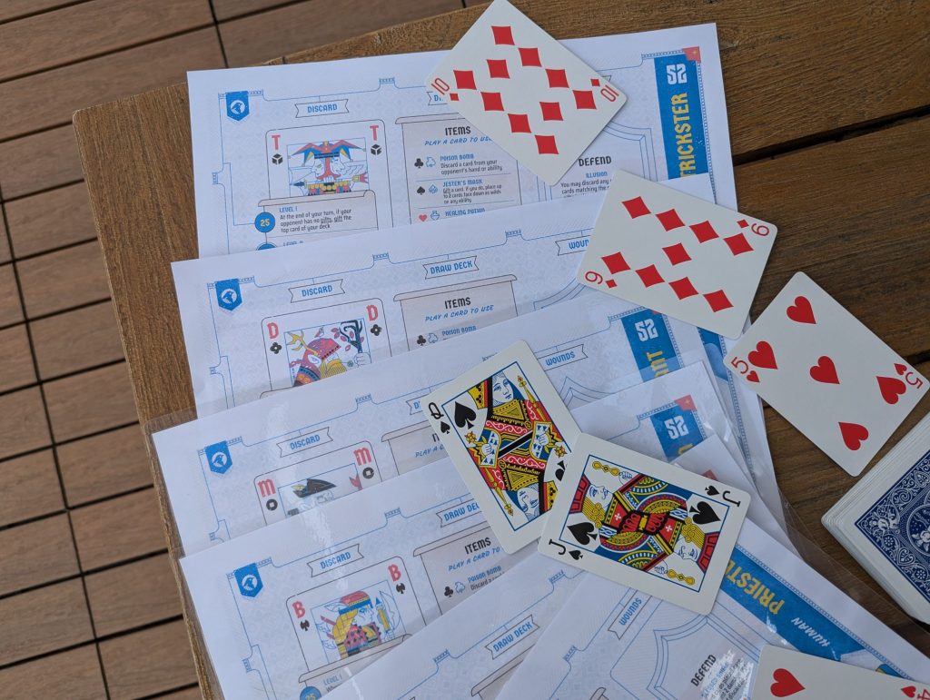 the character sheets of 52 duels spread out with some basic french-suited deck cards spread out across it