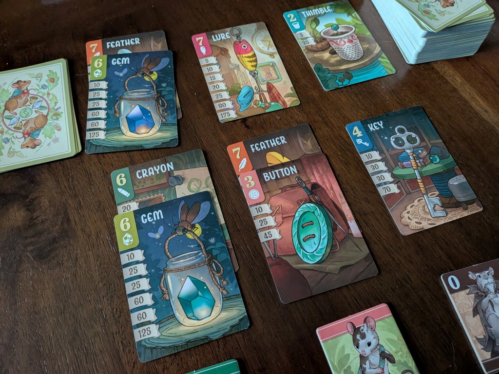 The market of Trinket Trove set up on table. Two players have bid two cards, while a third has taken their free bid.