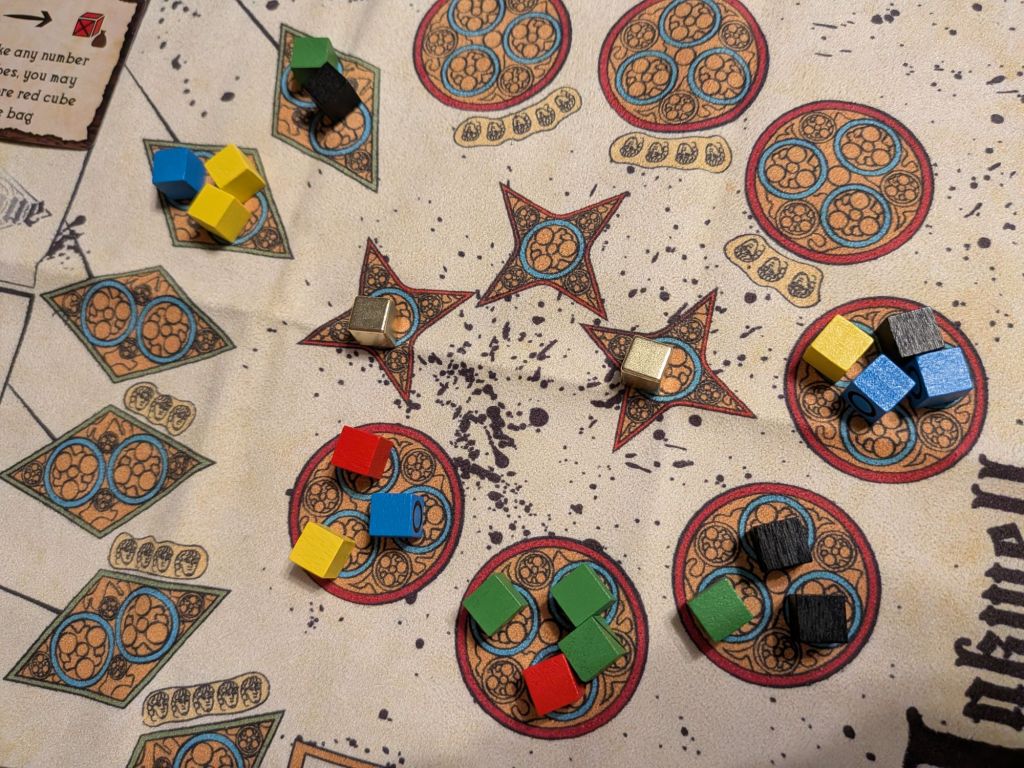 the cloth playmat of Inkwell, laid out with various ink cubes in different wells